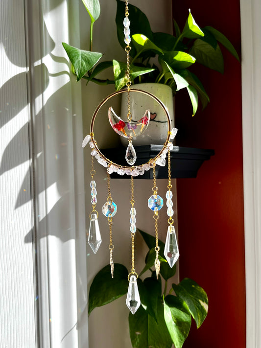 Suncatcher with pressed flower petals in crescent moon