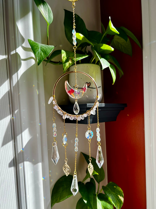 Suncatcher with pressed flower petals in crescent moon